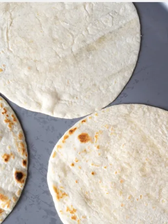 Imagem mostra tres tortillas de trigo sobre assadeira